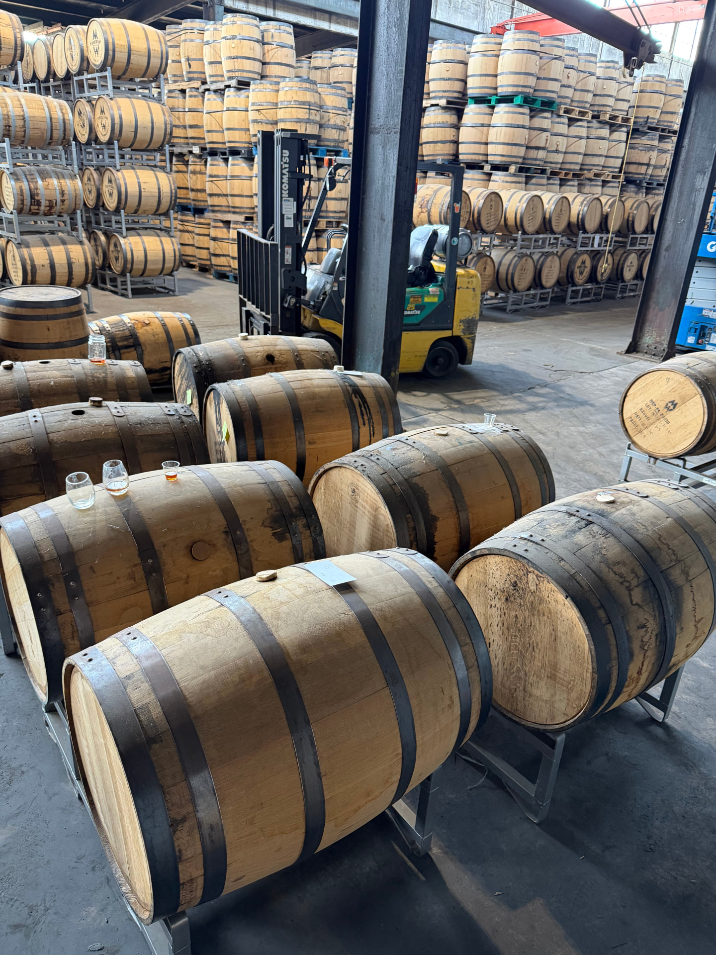 Rows of oak bourbon barrels resting in a dim warehouse